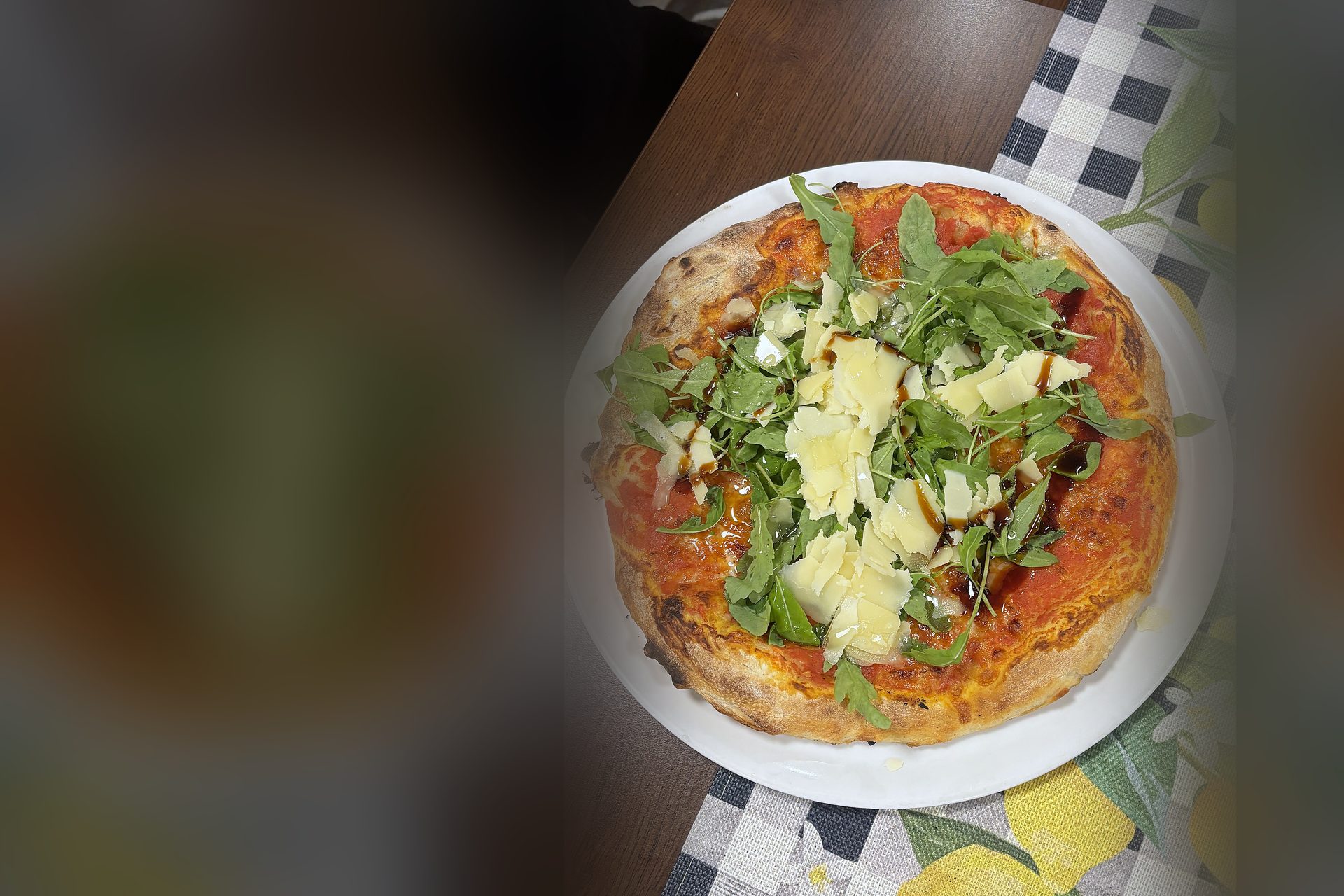 Pizza mit Rucola und gehobeltem Parmesan aus dem Ofen